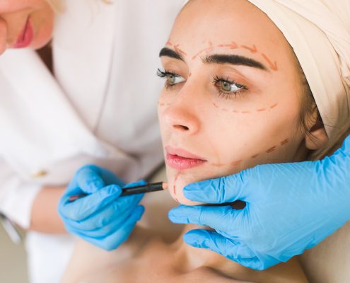 Doctor drawing marks on female face